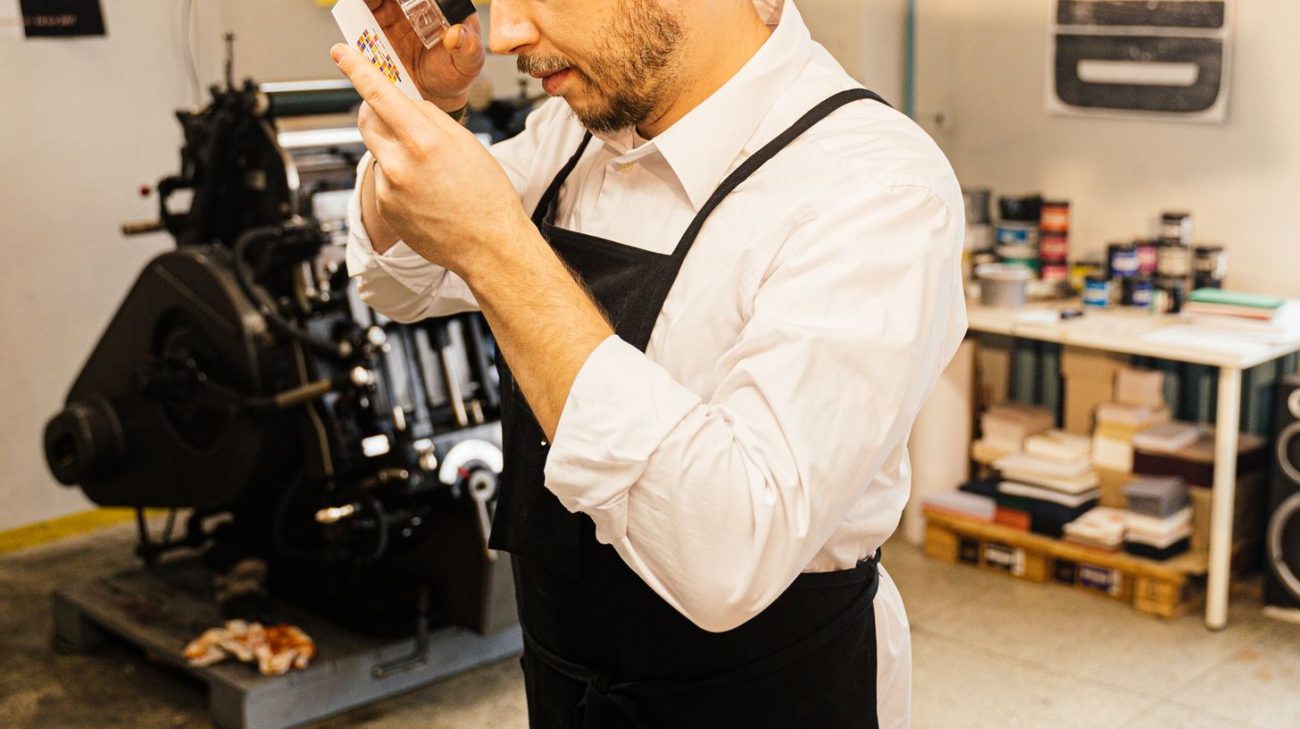 Designer checking fine print detail with a loupe before approving a label