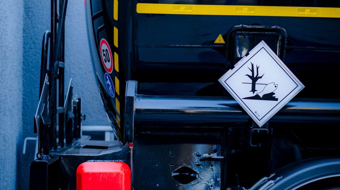 Dangerous goods placard on a transport vehicle beside chemical packaging