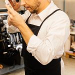 Designer checking label printer resolution with a magnifier over a printed sheet