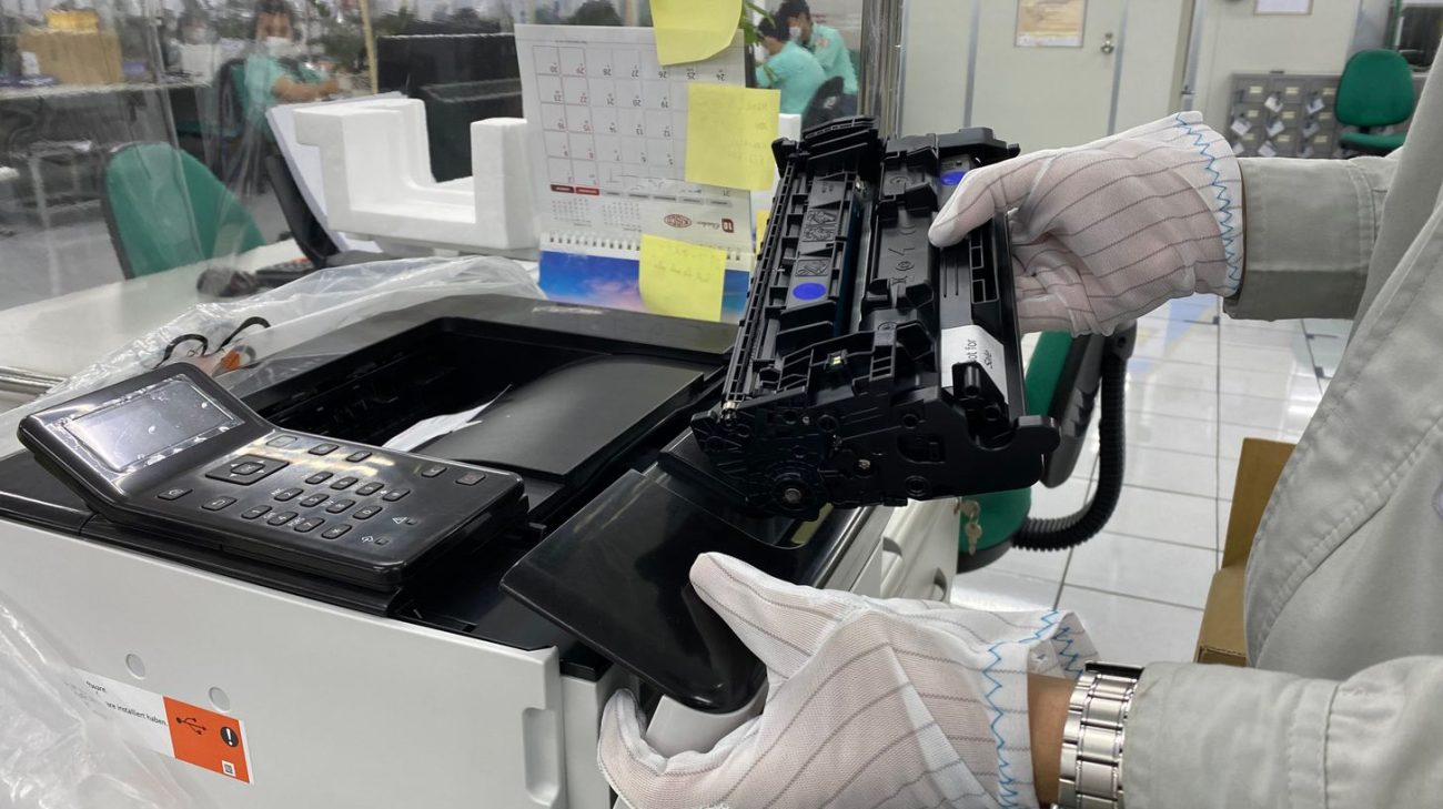 Worker replacing a consumable inside a printer in a laboratory