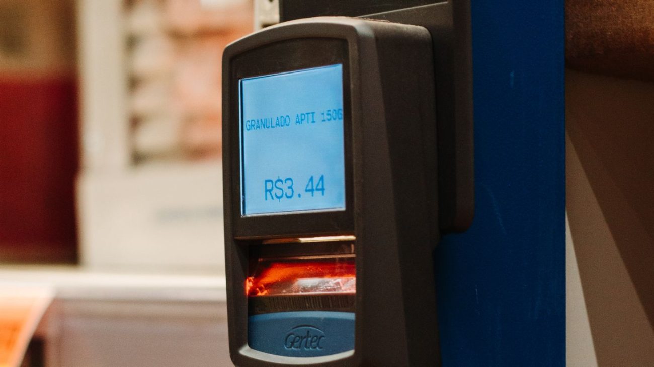 Retail point-of-sale scanner reading a product code at a checkout counter