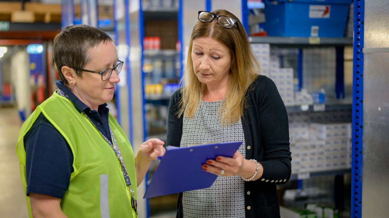 Supervisors checking stock records before an RFID rollout