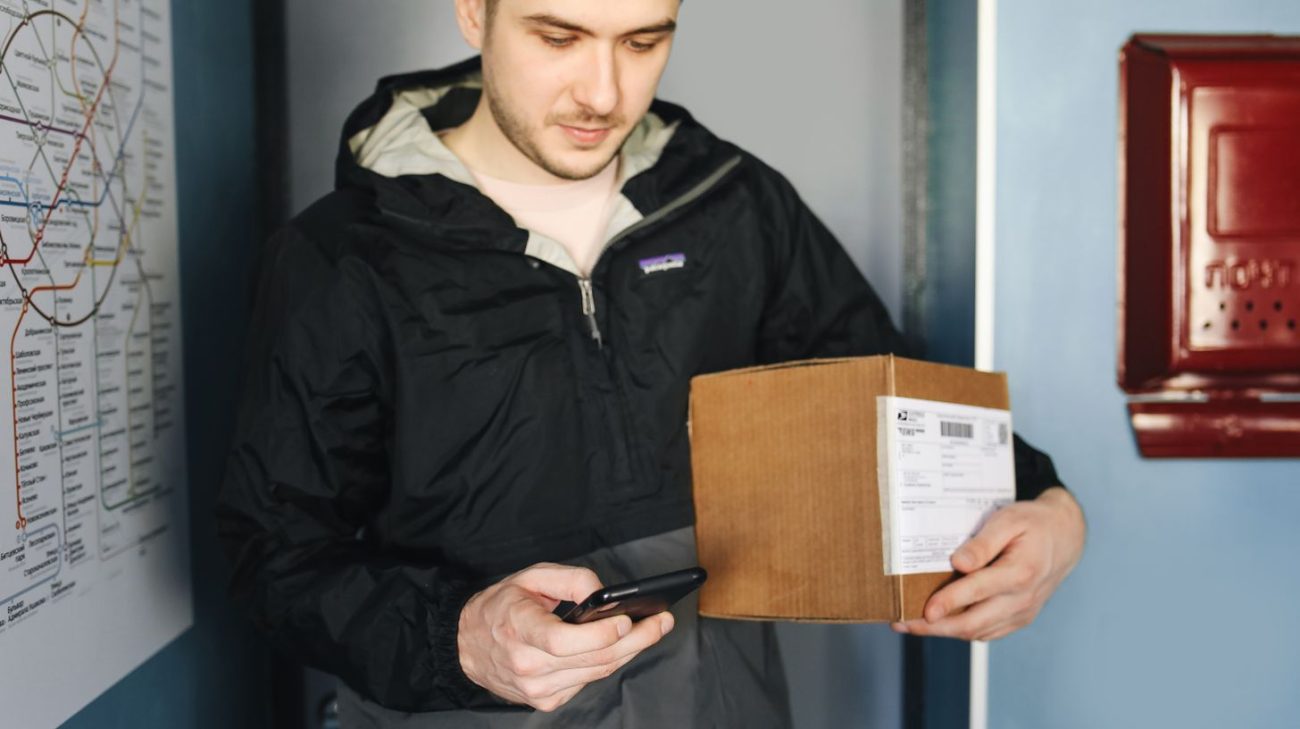 Worker scanning a shipping label with a smartphone camera