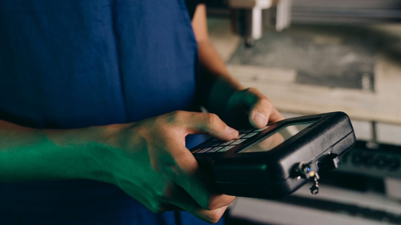 Technician checking a coder with a handheld control device